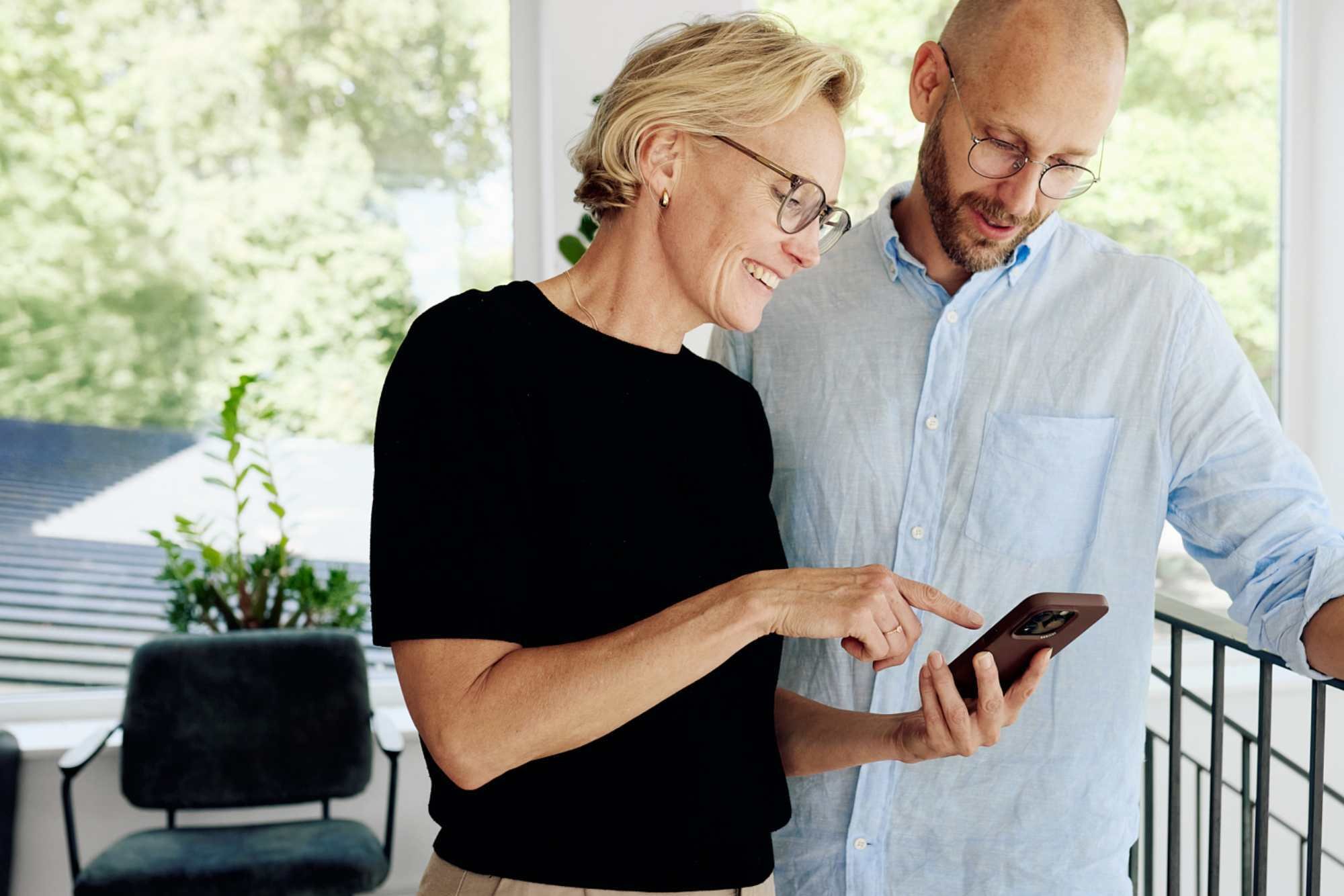 A female and a male co-worker looking at something in a mobile
