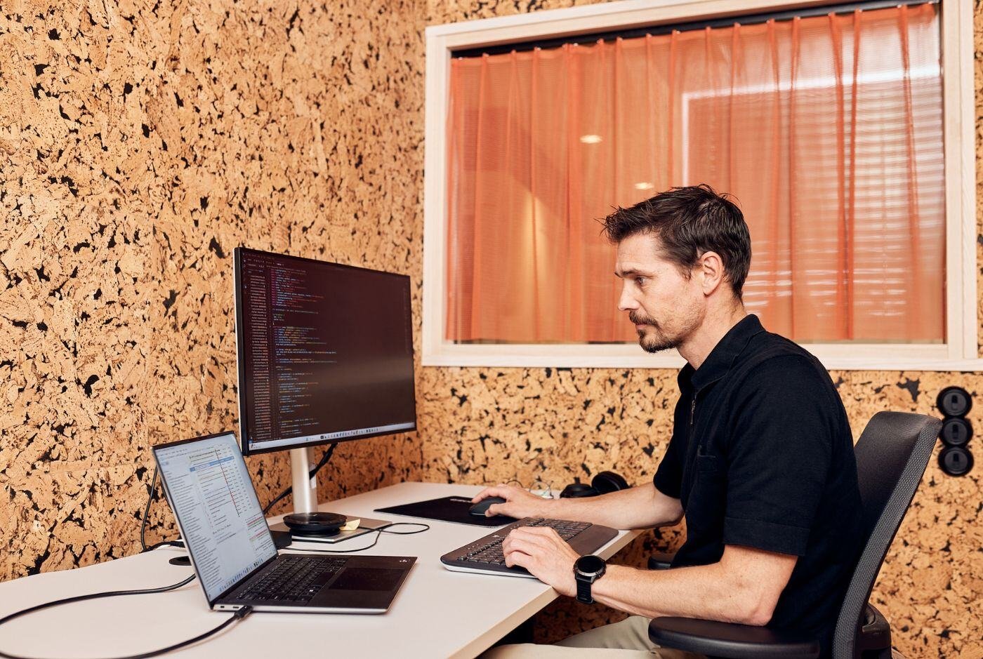 A focused web developer coding at their computer