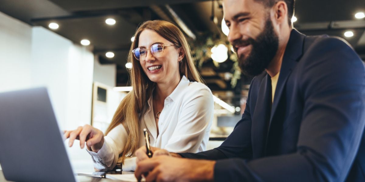 A female and a male colleague sitting by a computer