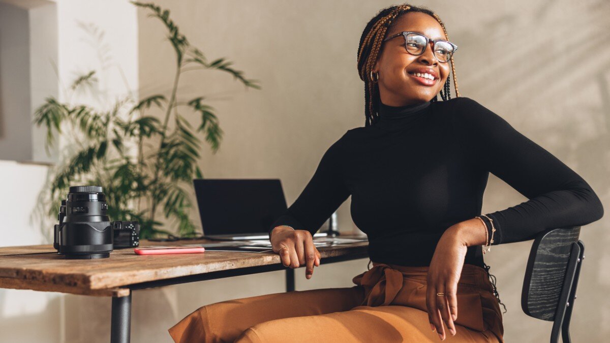 A woman sitting by her desk looking out through the window