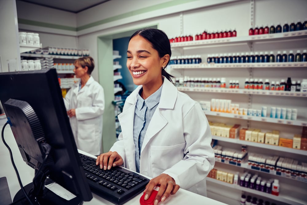 A smiling woman working in a pharmacy