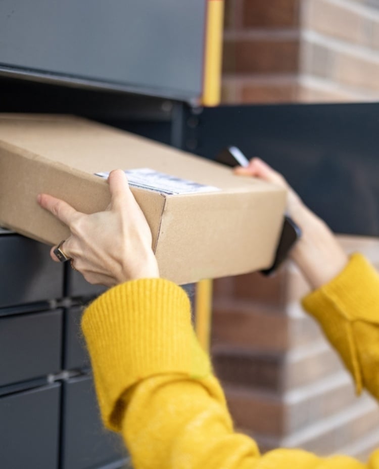Someone picking up a package from a parcel locker