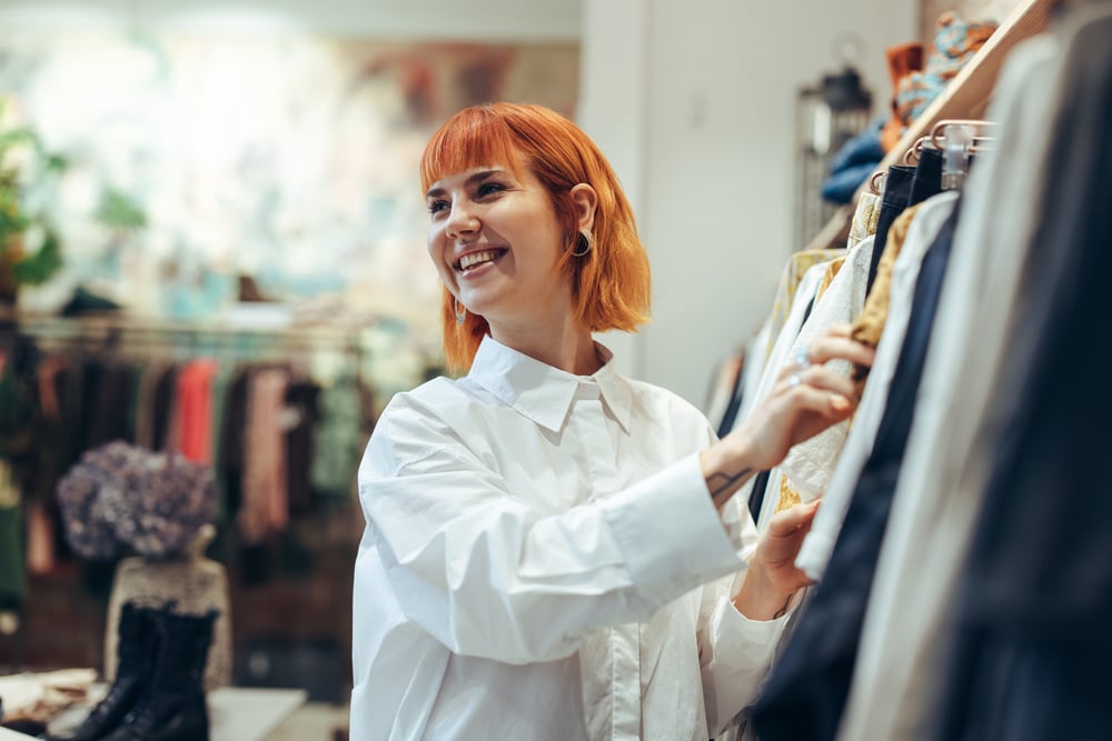 A retail employee organizing clothing items in the store