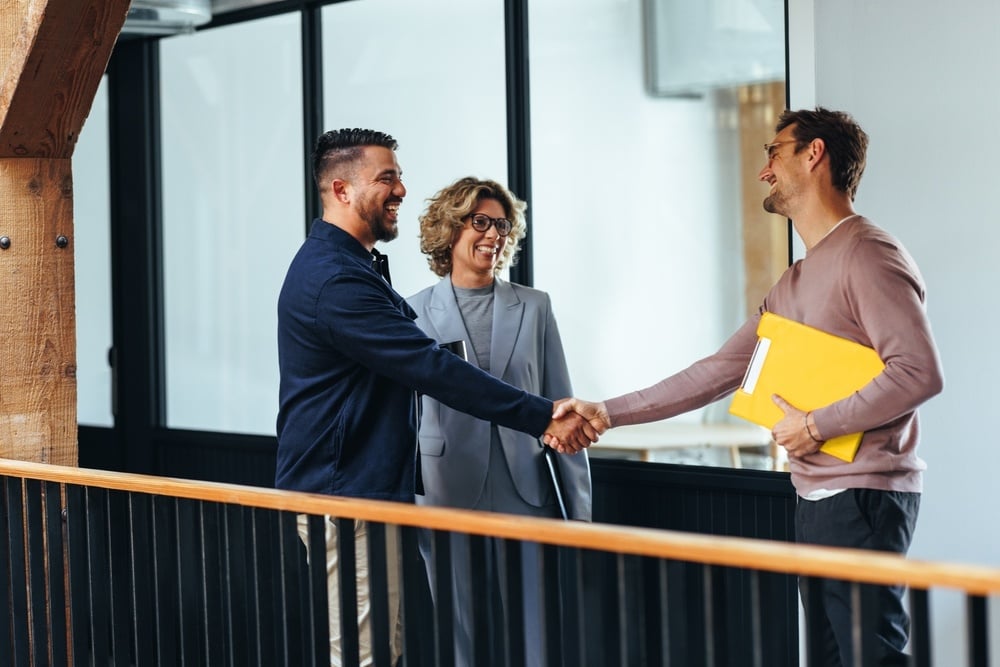 Three people greeting and hand shake with each other before a meeting