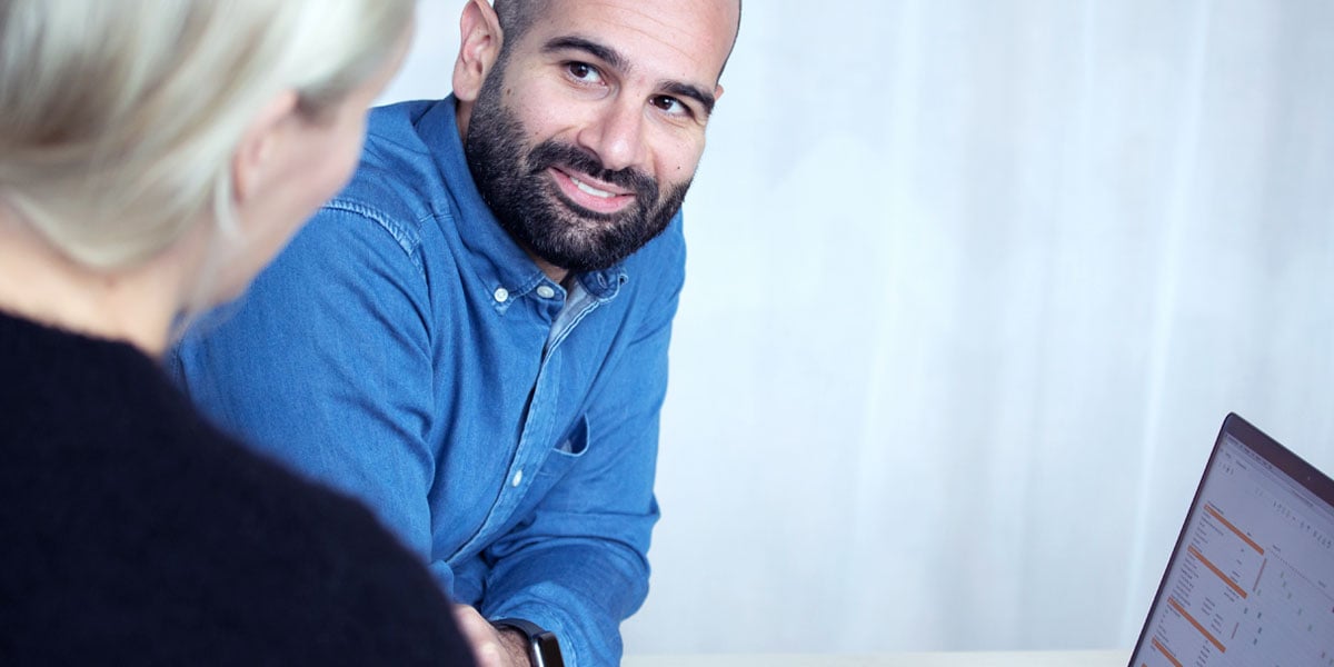 A male colleague listening to his female colleague while she's talking